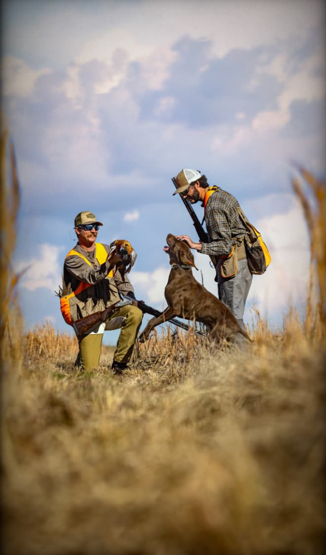 Hunters with gun dog after a successful hunt